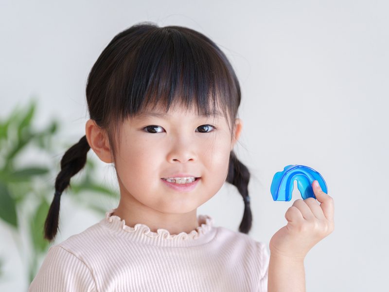 マウスピースで歯列矯正をする子供