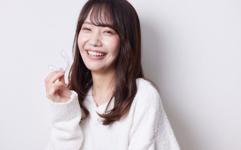 マウスピース矯正を持つ女性